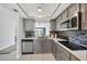 Bright kitchen boasts stainless steel appliances, gray cabinets, attractive tile backsplash and an island sink at 275 Mission W Trl # G, Venice, FL 34285