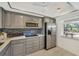 Modern kitchen with sleek gray cabinets, stainless steel appliances, and stylish backsplash, creating a functional and inviting space at 275 Mission W Trl # G, Venice, FL 34285