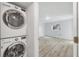 Laundry area offers stacked washer and dryer and adjacent bedroom at 275 Mission W Trl # G, Venice, FL 34285