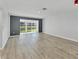 Spacious living room with sleek wood flooring, fresh paint, and sliding glass doors offering natural light and serene views at 275 Mission W Trl # G, Venice, FL 34285