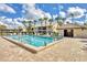 Sparkling community pool with lounge chairs, palm trees, and a clubhouse for residents to enjoy at 275 Mission W Trl # G, Venice, FL 34285