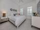 Bright bedroom with a queen size bed, ceiling fan and neutral decor at 29176 Coral Harbour Dr, Englewood, FL 34223