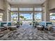 Community clubhouse seating area with a view of the pool, lounge chairs, palm trees, and tiled patio at 29176 Coral Harbour Dr, Englewood, FL 34223