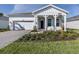 Charming single-story home featuring a well-manicured lawn, paver driveway, and a welcoming porch at 29176 Coral Harbour Dr, Englewood, FL 34223