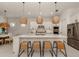 Bright, modern kitchen with white cabinets, stainless steel appliances and large island with seating at 29176 Coral Harbour Dr, Englewood, FL 34223