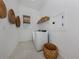 Bright laundry room featuring a white washer and dryer with woven baskets and stylish wall decor at 29176 Coral Harbour Dr, Englewood, FL 34223