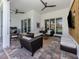 Spacious outdoor patio with comfortable seating, ceiling fans, and views of the lush backyard at 29176 Coral Harbour Dr, Englewood, FL 34223