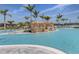 Beautiful swimming pool with a waterfall feature, surrounded by palm trees and comfortable seating at 29176 Coral Harbour Dr, Englewood, FL 34223
