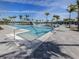 Expansive pool area featuring a zero-entry pool, lounge chairs, palm trees and spacious deck for relaxation at 29176 Coral Harbour Dr, Englewood, FL 34223