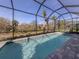 The clear swimming pool is caged in with an idyllic outdoor scenery of trees and sunshine at 29176 Coral Harbour Dr, Englewood, FL 34223
