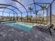 Sparkling pool is enclosed with a screened lanai, palm trees, and comfortable lounge chairs at 29176 Coral Harbour Dr, Englewood, FL 34223