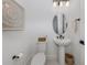 Cozy powder room with a pedestal sink, oval mirror, and decorative wall art at 29176 Coral Harbour Dr, Englewood, FL 34223