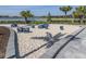 Inviting sand box area for residents with modern seating and nearby palm trees overlooking the lake at 29176 Coral Harbour Dr, Englewood, FL 34223