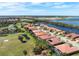 An aerial view of the property shows its location near a lake, golf course, and other beautiful homes in the community at 297 Martellago Dr, North Venice, FL 34275
