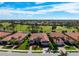 Expansive aerial view of a neighborhood showcasing well-maintained homes, lush landscaping, and a scenic golf course at 297 Martellago Dr, North Venice, FL 34275