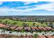 Aerial view of a residential neighborhood showcasing the home near a lush green golf course and tranquil lake at 297 Martellago Dr, North Venice, FL 34275