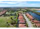 Aerial view of home with pool, landscaping, and golf course in background at 297 Martellago Dr, North Venice, FL 34275