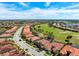 An aerial view showcases the home's location near a lush green golf course and other homes with beautiful landscaping at 297 Martellago Dr, North Venice, FL 34275