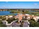 Aerial view of a golf course community with picturesque lakes, lush greenery, and a grand clubhouse at 297 Martellago Dr, North Venice, FL 34275