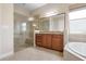 Bathroom showcasing a walk-in shower with glass door and dual-sink vanity with granite countertop at 297 Martellago Dr, North Venice, FL 34275