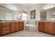 Spacious bathroom featuring a soaking tub, dual vanities, and granite countertops at 297 Martellago Dr, North Venice, FL 34275