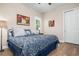 Comfortable bedroom with patterned bedding, a window with shutters, and wood flooring at 297 Martellago Dr, North Venice, FL 34275