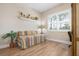 Well-lit bedroom with a daybed, a window with shutters, and hardwood-style flooring at 297 Martellago Dr, North Venice, FL 34275