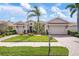 Beautiful single-story home with a lush front lawn, a palm tree, a tile roof, and a two-car garage at 297 Martellago Dr, North Venice, FL 34275