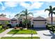 Charming home with a three-car garage, well-manicured lawn, beautiful landscaping, and a brick driveway at 297 Martellago Dr, North Venice, FL 34275