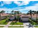 Beautiful home with a three-car garage, well-manicured lawn, lush landscaping, and a brick driveway at 297 Martellago Dr, North Venice, FL 34275