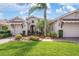 Charming home with a manicured front yard, tile roofing, and a private entrance with mature landscaping at 297 Martellago Dr, North Venice, FL 34275