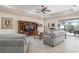 Bright living room boasts tile floors, ceiling fan, and access to the outdoor pool area at 297 Martellago Dr, North Venice, FL 34275