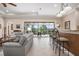 Spacious living area with a stylish wet bar, large windows offering views of the outdoor patio, and comfortable seating at 297 Martellago Dr, North Venice, FL 34275
