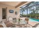 Covered patio with outdoor seating overlooking pool and fenced backyard at 297 Martellago Dr, North Venice, FL 34275