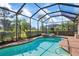 Screened-in pool and spa with lush landscaping create a relaxing outdoor oasis at 297 Martellago Dr, North Venice, FL 34275