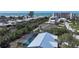 Aerial view of a residential area with a swimming pool surrounded by lush greenery near the beach at 388 Flamingo Dr, Venice, FL 34285
