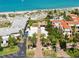 Aerial view of coastal real estate, highlighting beachfront access, lush landscaping, and surrounding community at 388 Flamingo Dr, Venice, FL 34285