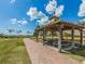 Community gazebo with picnic tables and benches, surrounded by a grassy area and palm trees at 388 Flamingo Dr, Venice, FL 34285
