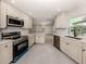 Modern kitchen boasts stainless steel appliances, custom white cabinets, and elegant granite countertops at 388 Flamingo Dr, Venice, FL 34285