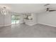 Spacious living area with stylish gray tile flooring, a modern light fixture, and sliding glass doors to the pool area at 388 Flamingo Dr, Venice, FL 34285