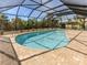 Inviting in-ground screened pool with a paved deck and lush landscaping to ensure privacy in backyard at 388 Flamingo Dr, Venice, FL 34285