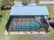 Aerial view of a screened-in pool and patio area, surrounded by a lush green yard at 388 Flamingo Dr, Venice, FL 34285