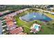 Expansive aerial view of a community featuring a central lake, lush landscaping, and a community pool at 4398 Summertree Rd, Venice, FL 34293