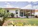 Backyard with a red tile roof, a palm tree, and a screened-in lanai at 4398 Summertree Rd, Venice, FL 34293