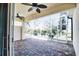 An outdoor covered lanai with brick flooring and screen enclosure, offering views of the landscaped yard at 4398 Summertree Rd, Venice, FL 34293