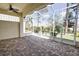 Screened-in lanai with brick flooring, ceiling fan, and an expansive outdoor view at 4398 Summertree Rd, Venice, FL 34293