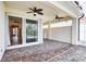 Screened-in lanai with brick flooring, ceiling fans, and sliding glass door entry at 4398 Summertree Rd, Venice, FL 34293