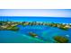 Aerial view of waterfront homes, lush islands, and scenic waterway showcasing the beauty of coastal living at 471 Bayshore Rd, Nokomis, FL 34275