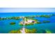 Aerial view showcasing a unique island community with waterfront homes and lush greenery at 471 Bayshore Rd, Nokomis, FL 34275