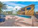 Beautiful backyard with a pool, brick patio, palm trees, and a view of the two-story home at 471 Bayshore Rd, Nokomis, FL 34275